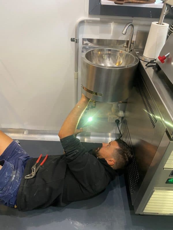 Plumber installing a commercial kitchen