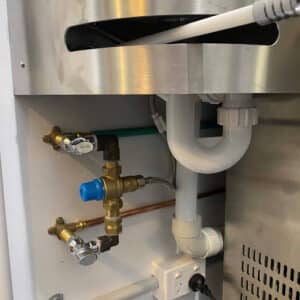 Modern plumbing pipes and fixtures under a sink, illustrating tips for choosing the best plumber in Melbourne.