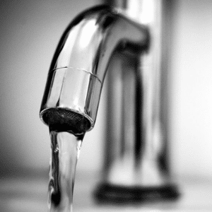Close up of water running from a tap faucet.