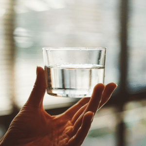 A hand holding a glass of drinking water in Melbourne